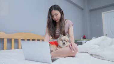 Tatil konsepti 4k Çözünürlük. Yatak odasında bilgisayarla çalışan Asyalı kızlar..