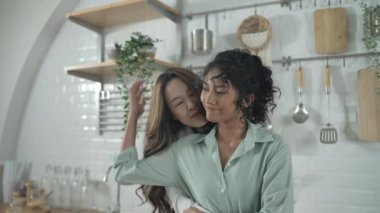Tatil konsepti 4k Çözünürlük. Asyalı kadınlar mutfakta birbirini kucaklıyor. Genç kadınların ortak bir lezbiyen ilişkisi var..