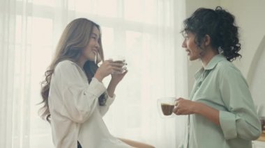 Tatil konsepti 4k Çözünürlük. Asyalı kadınlar mutfakta kahve içiyorlar. Genç kadınların ortak bir lezbiyen ilişkisi var..