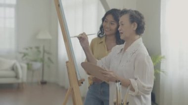 Sanatçı konsepti 4k Çözünürlük. Asyalı aileler oturma odasında bir araya geliyorlar. Sanatçı iş yaratıyor. Boş zaman aktiviteleri ve hobileri.