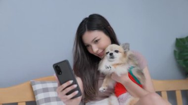 Tatil konsepti 4k Çözünürlük. Asyalı kızlar yatak odasında cep telefonlarıyla oynuyorlar. Akıllı bir telefonla fotoğraf çek..