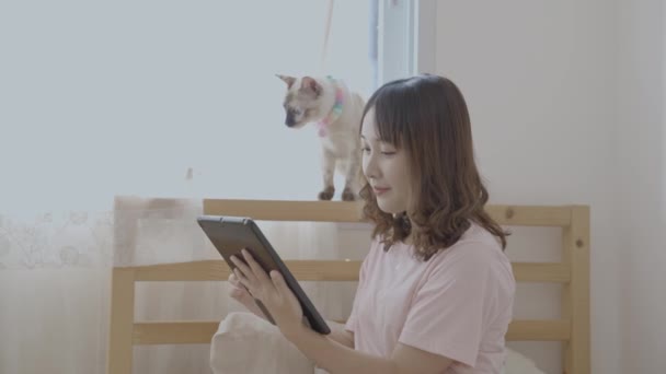 假日4K解像度的概念 亚洲女人在卧室里玩平板电脑 — 图库视频影像