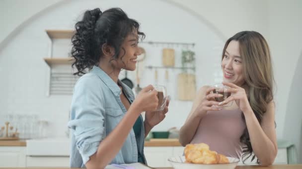 Ünnepi koncepció 4k felbontás. Ázsiai nők kávéznak együtt a konyhában. A fiatal nők kölcsönös leszbikus szerelmi kapcsolatban élnek..