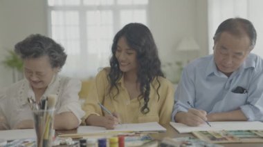 Sanatçı konsepti 4k Çözünürlük. Asyalı aileler oturma odasında bir araya geliyorlar. Sanatçı iş yaratıyor. Boş zaman aktiviteleri ve hobileri.