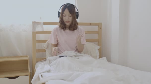 4K解像度の休日の概念 寝室で音楽を聴いているアジアの女性 休日のエンターテイメント活動 — ストック動画