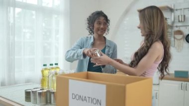 4k Çözünürlük Gönüllü konsepti. Asyalı kadınlar evde bağış kutusunda yiyecek paketliyorlar. Kurbanlara yardım etmek için bağışlanan tüketici malları.