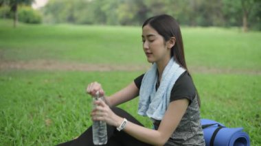 4k Çözünürlük alıştırması. Asyalı kadınlar terleyene kadar egzersiz yaptıktan sonra mola verip su içerler..