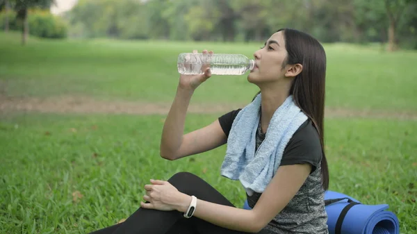 Exercise concept of 4k Resolution. Asian women take a break and drink water after exercising until they sweat.