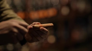 Night club concept of 4k Resolution. Close-up of the hand of an Asian man cutting a cigar in a restaurant.