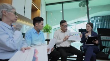 4k Kararlılığın iş konsepti. Asyalı genç iş adamları grubu ofiste toplantı yapıyor. Sıradan iş planı.
