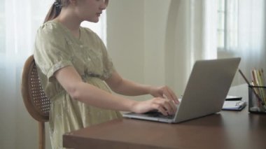 Hamile kadın konsepti 4k Kararlılık. Asyalı kadınlar tatilde evlerinde evrak işleriyle uğraşıyorlar.