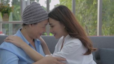 Aile kavramı 4k Kararlılığı. Anne ve kızı oturma odasında birbirlerinin kafalarına dokunuyorlar..