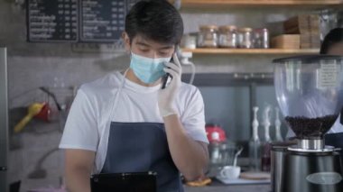 Kafe konsepti 4k Kararlılık. Bir çalışan, içki siparişi vermek için arayan bir müşterinin telefonuna cevap veriyor..