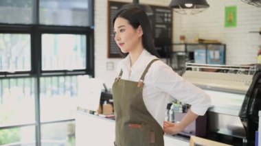 Coffee shop concept of 4k Resolution. Asian women are preparing to open a shop with confidence. Employee wearing aprons.