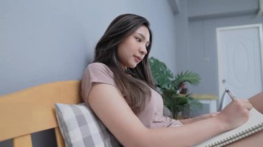 Tatil konsepti 4k Çözünürlük. Asyalı kızlar yatak odasında notlar yazıyorlar..