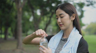 4k Çözünürlük alıştırması. Kız ter döken egzersizden sonra su içmek için dinleniyor..