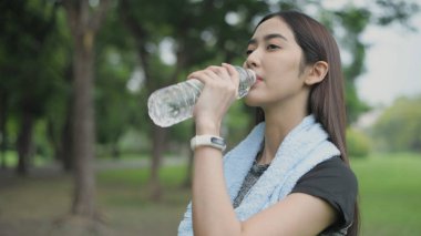 4k Çözünürlük alıştırması. Kız ter döken egzersizden sonra su içmek için dinleniyor..