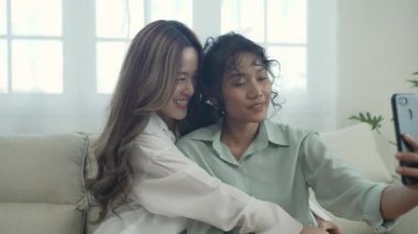 4k Çözünürlük ev arkadaşı konsepti. Asyalı kadınlar oturma odasında resim çekiyorlar..