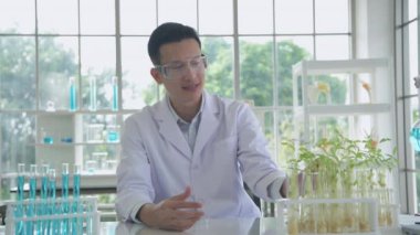 Research concept of 4k resolution. Asian scientists are describing plant growth observations in the laboratory.
