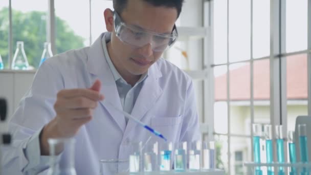 Forskningskoncept För Upplösning Asiatisk Man Droppar Vätska Ett Provrör — Stockvideo