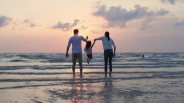 Tatil konsepti 4k Çözünürlük. Asyalı ebeveynler ve kızlar sahilde eğleniyorlar. Yaz tatili.