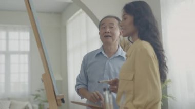 Sanatçı konsepti 4k Çözünürlük. Galeride Asyalı bir kadın çalışmalarını sunuyor. Sanatçı iş yaratıyor. Boş zaman aktiviteleri ve hobileri.