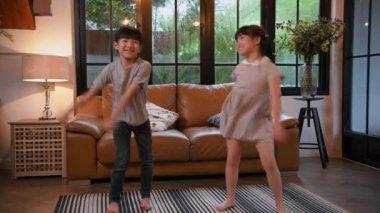 Family concept of 4k Resolution. Asian children dance together happily in the living room.