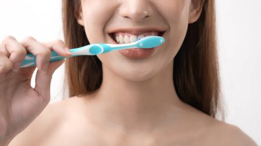 4k Çözünürlük 'ün güzellik konsepti. Beyaz arka planda diş fırçalayan Asyalı kadın..