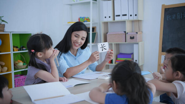 (Китайская формулировка transcape: insehr) Образовательная концепция 4k Resolution. Учитель учит детей учить китайский язык в классе.