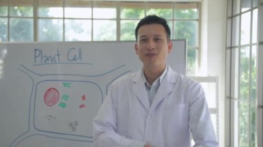 Araştırma konsepti 4K çözünürlüğü. Asyalı bilim adamları laboratuvarda gururla gülümsüyor..
