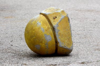 Eski harap olmuş ve hasarlı betonu devirmiş. Güneşli bir bahar gününde, asfalt otoparkın tepesinde yuvarlak, sarı bir park alanı var.