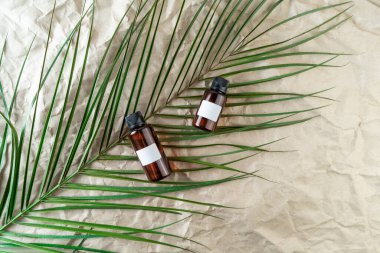 Bej el işi kağıt arka planda üzerinde boş etiketler bulunan bir yüz serumu ya da temel yağ.