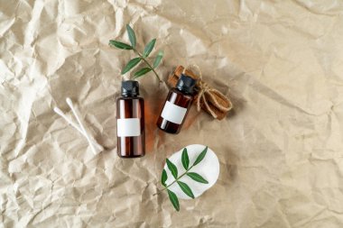 Bej el işi kağıt arka planda üzerinde boş etiketler bulunan bir yüz serumu ya da temel yağ.