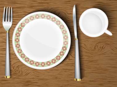 boş bir levha ile ahşap bir masa üzerine çatal bıçak takımı