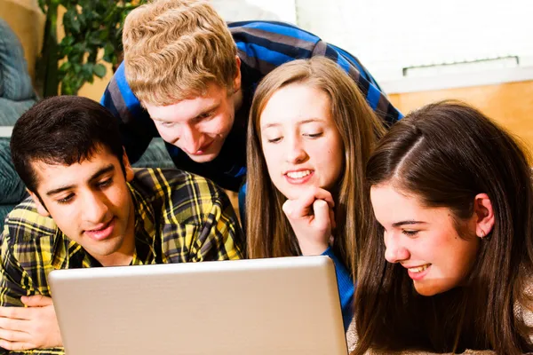 Teens crowd around computer — Stock Photo, Image