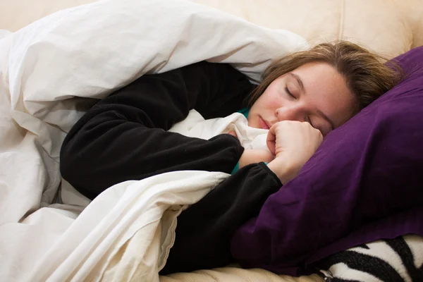 Sjuk ung kvinna sover på soffan — Stockfoto