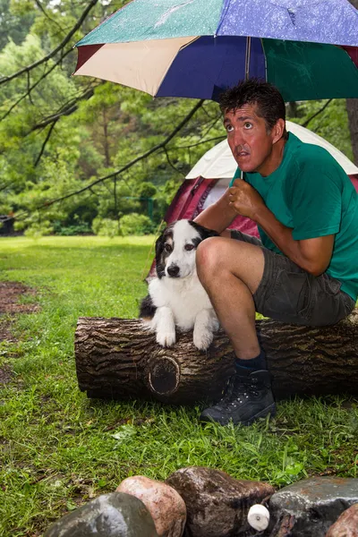 Camper huddles in the rain — Stock Photo, Image