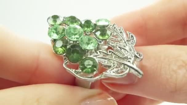 Anillo de joyería con cristales de esmeralda verde poniendo en el dedo — Vídeo de stock