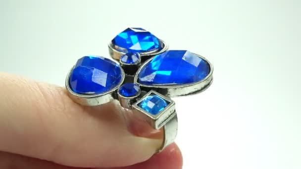 Ювелірне кільце з блакитними кристалами сапфіру, що надягають на палець — стокове відео