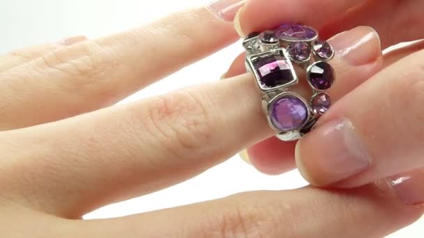 Jewelery ring with purple crystals putting on the finger