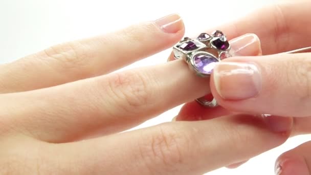 Jewelery ring with purple crystals putting on the finger — Stock Video