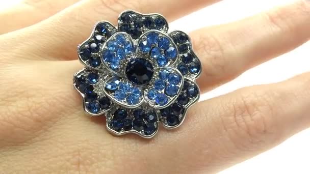 Jewelery ring with blue sapphire crystals putting on the finger — Stock Video