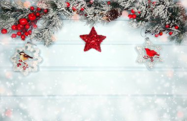 Kış Noel arkaplanında köknar dalları ve mavi ahşap dokuda kar var.                              