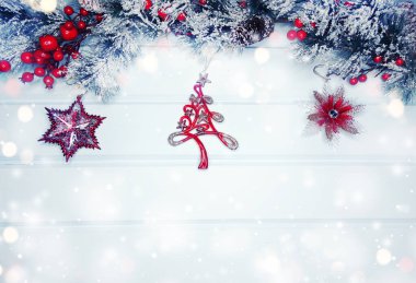 Kış Noel arkaplanında köknar dalları ve mavi ahşap dokuda kar var.                              