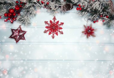 Kış Noel arkaplanında köknar dalları ve mavi ahşap dokuda kar var.                              