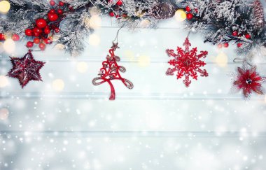 Kış Noel arkaplanında köknar dalları ve mavi ahşap dokuda kar var.                              
