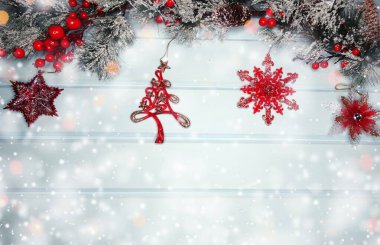 Kış Noel arkaplanında köknar dalları ve mavi ahşap dokuda kar var.                              