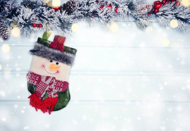 mavi ahşap doku üzerinde noel kardan adam oyuncak kış dalları konileri ve kar                              