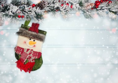 mavi ahşap doku üzerinde noel kardan adam oyuncak kış dalları konileri ve kar                              