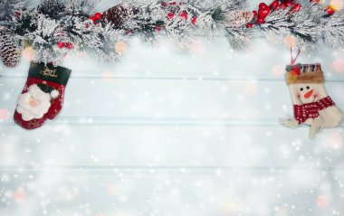 Kış Noel arkaplanında köknar dalları ve mavi ahşap dokuda kar var.                              